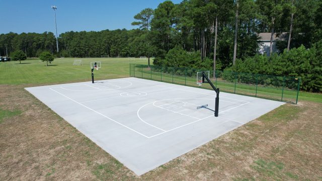 Poquoson, VA Excavated & installed an 84’ by 50’ outdoor basketball court, Striped court with standard high school basketball markings, Installed vinyl chain link fencing